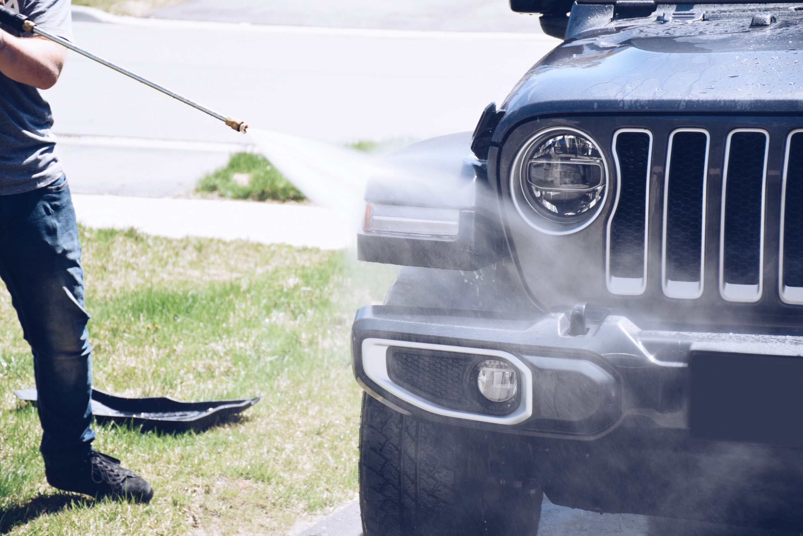 A man washing his Jeep to repair bumper scratch