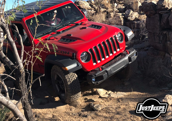 Red Jeep Wrangler driving through the mountains